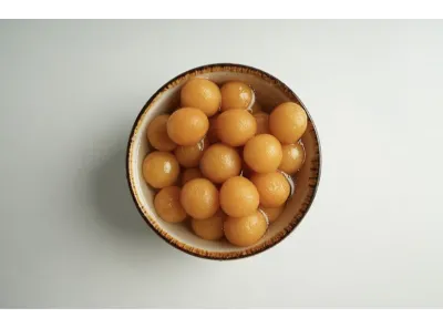 Bowl filled with small, golden angoori gulab jamun soaked in sugar syrup
