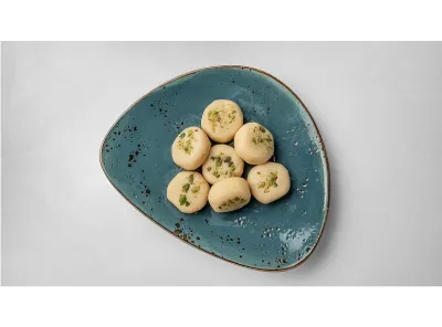 Seven pieces of Dudh Peda garnished with chopped pistachios