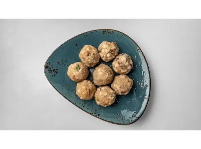 Homemade gond badam laddus arranged neatly on a blue ceramic plate, perfect for winter nourishment and festive treats.
