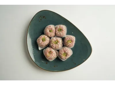Kaju Strawberry sweets topped with pistachio slivers, served in paper cups