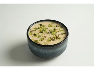 Bowl of creamy laccha rabdi topped with chopped pistachios