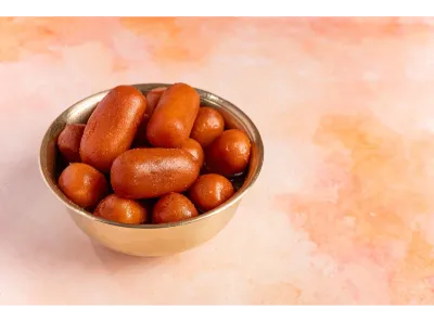 Bowl of golden brown lancha sweets soaked in syrup, served in a metal bowl