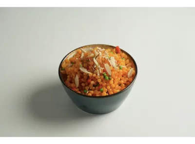 Sweet boondi garnished with sliced almonds and served in a dark bowl