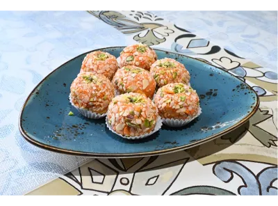 Sugarless Dry Fruit Ladoo made with a blend of chopped nuts and dates, rolled into round bites and garnished with pistachios.