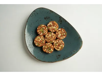 Sugarless Anjeer rolls made with figs and dry fruits, neatly arranged in a circular pattern, showing a rich and textured appearance.