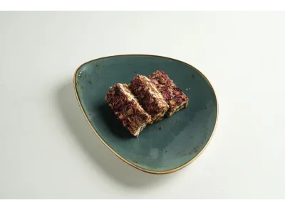 Three pieces of sugarless khajur (date) sweet garnished with dried rose petals
