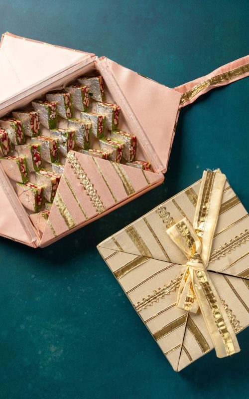 Handmade Gota gift boxes in vibrant colors with golden ribbon detailing.